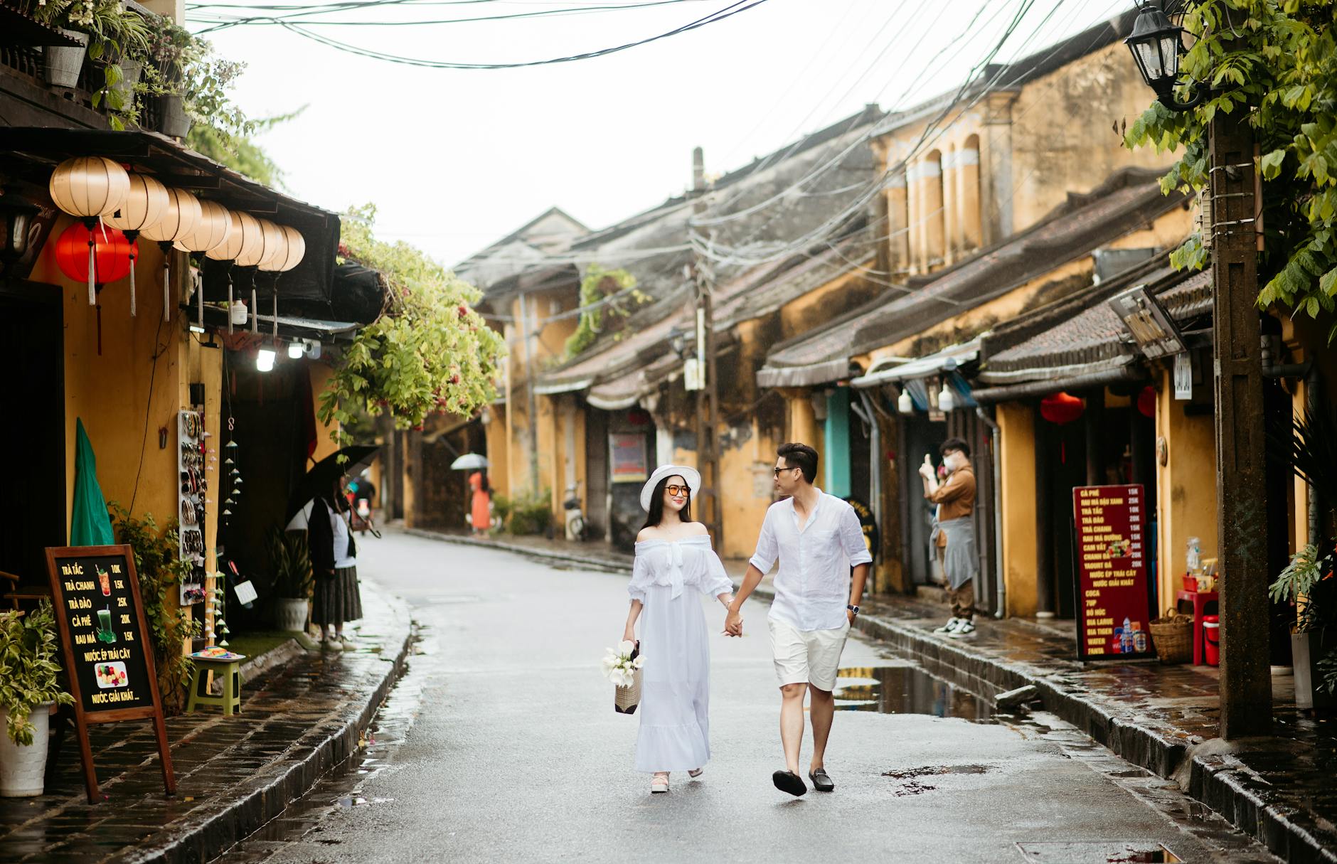 A couple walking hand in hand through the charming streets of Hoi An, Vietnam.