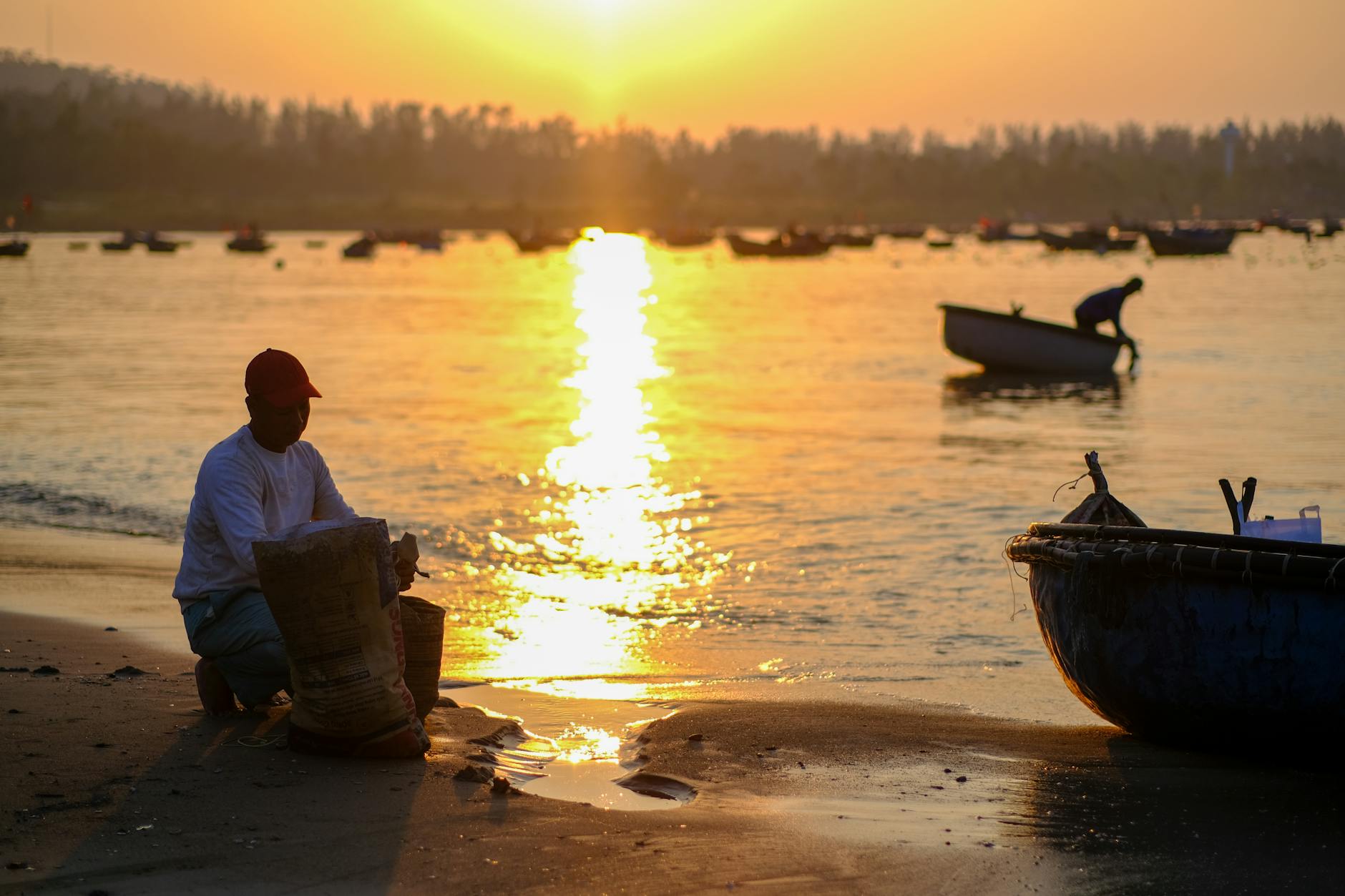 A serene morning scene of fishermen at Đà Nẵng beach during sunrise, capturing daily life in Vietnam.