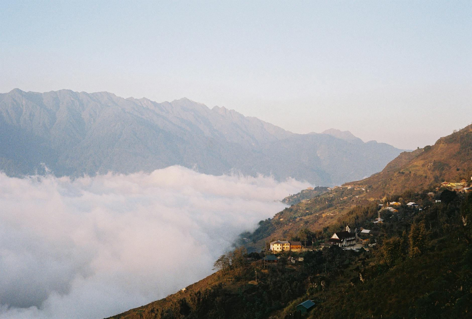 Ethereal sunrise over a misty mountain village in Lào Cai, Vietnam, capturing serene beauty and tranquility.
