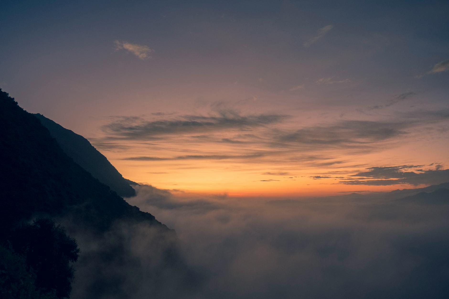 Stunning sunrise over misty mountains with a vibrant sky, creating a serene and breathtaking landscape.