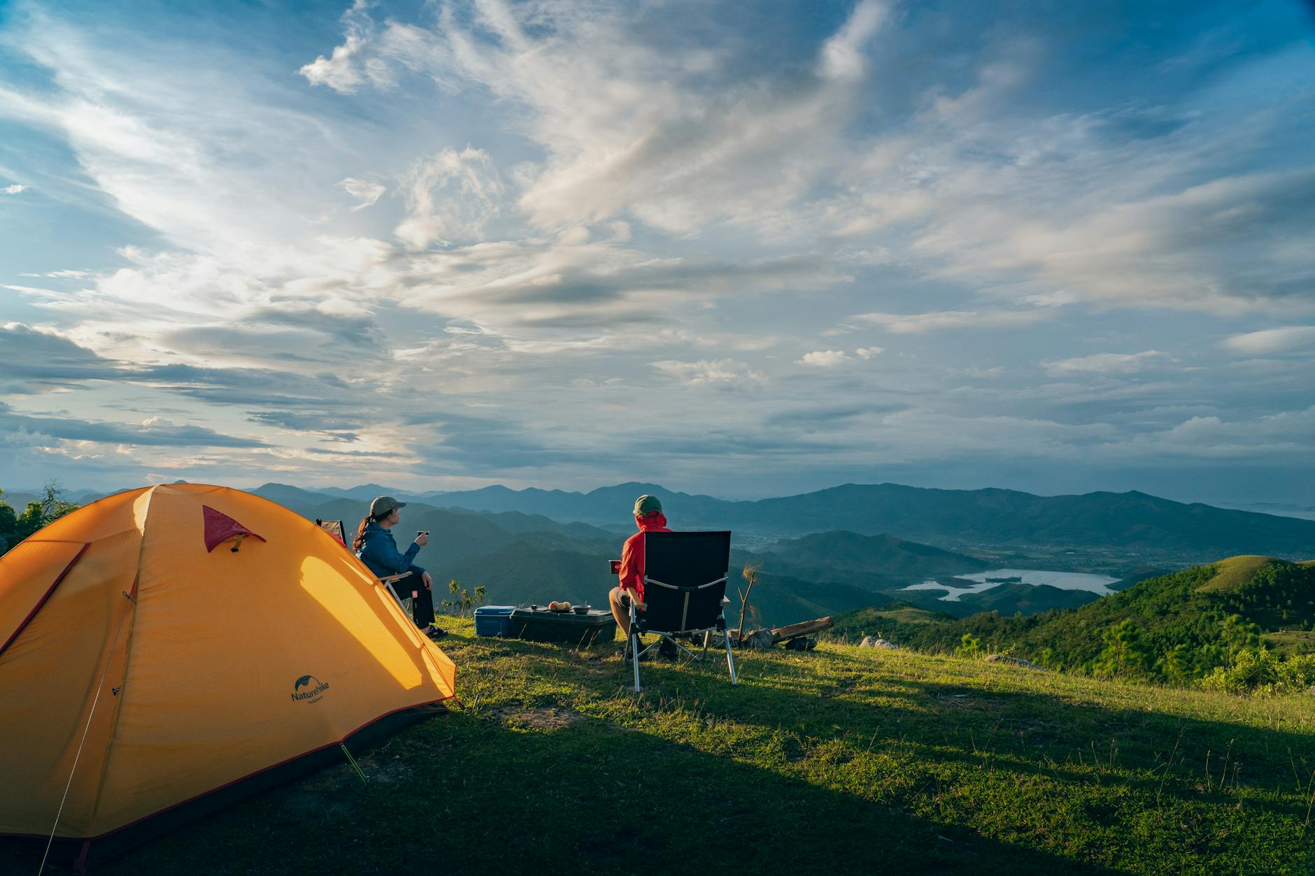 Two people enjoy a serene sunrise camping in the mountains of Quảng Ninh, Vietnam.