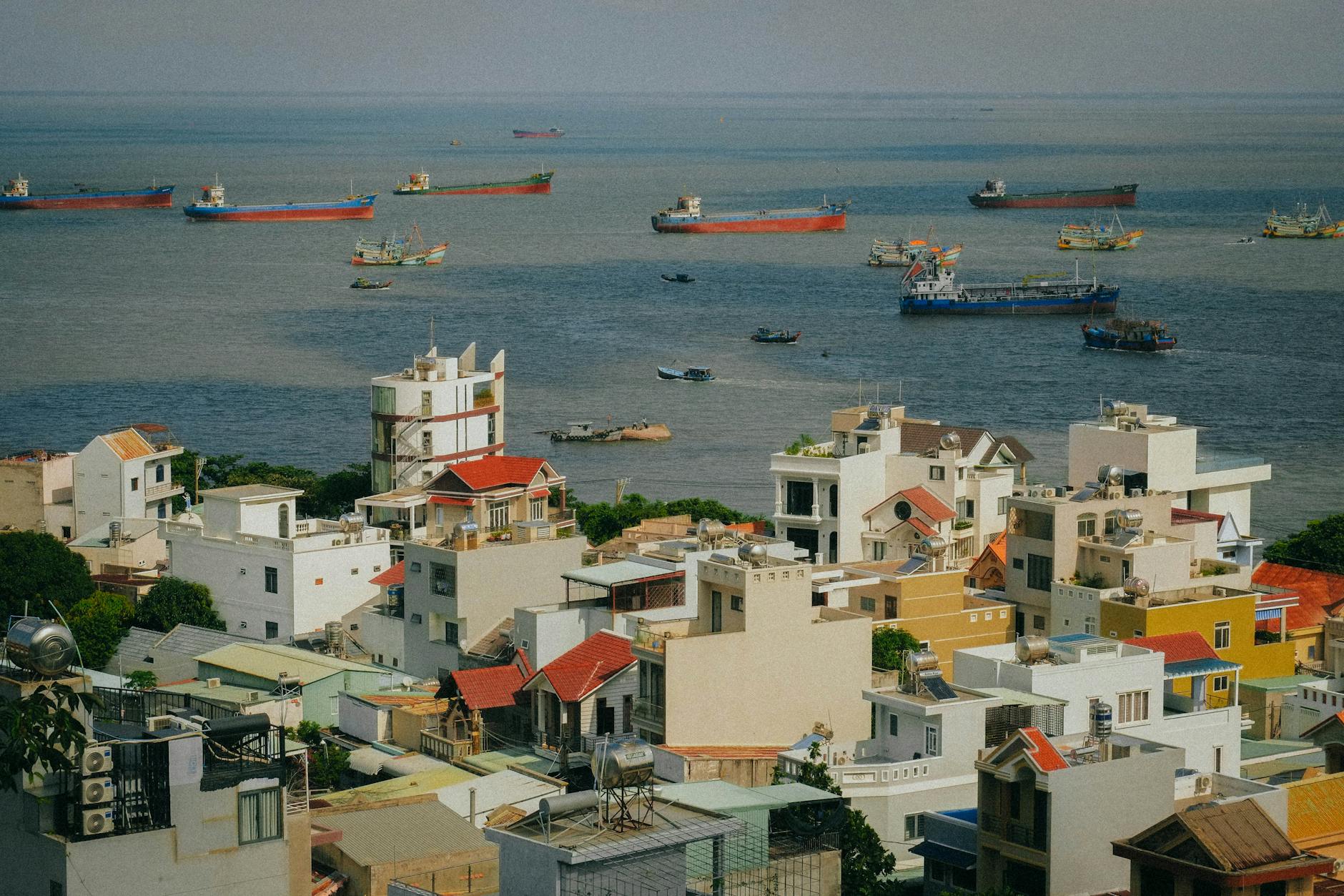 A picturesque view of Vũng Tàu city with ships on the sea and vibrant buildings in the foreground.