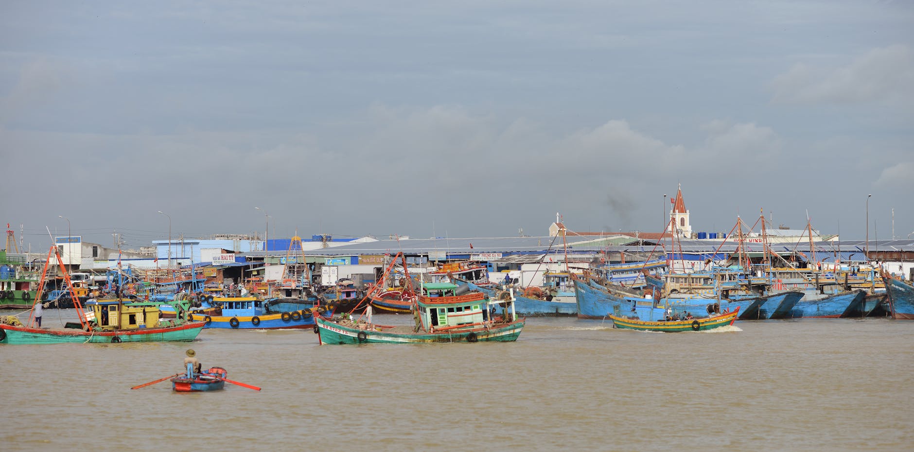 Scenic view of vibrant fishing boats docked at a bustling coastal fishing village.