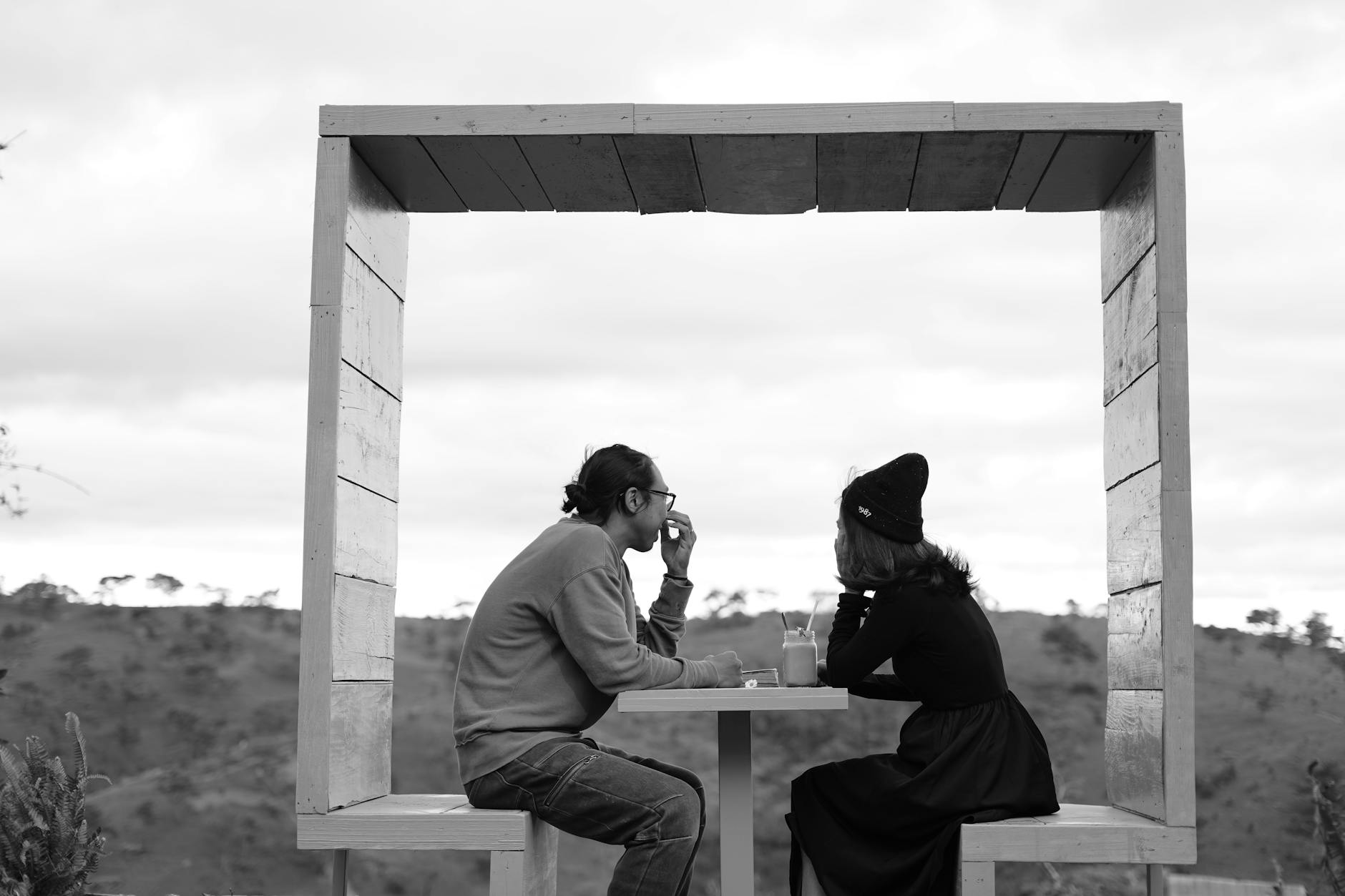 Two people conversing at a modern outdoor cafe in Dalat, Vietnam.