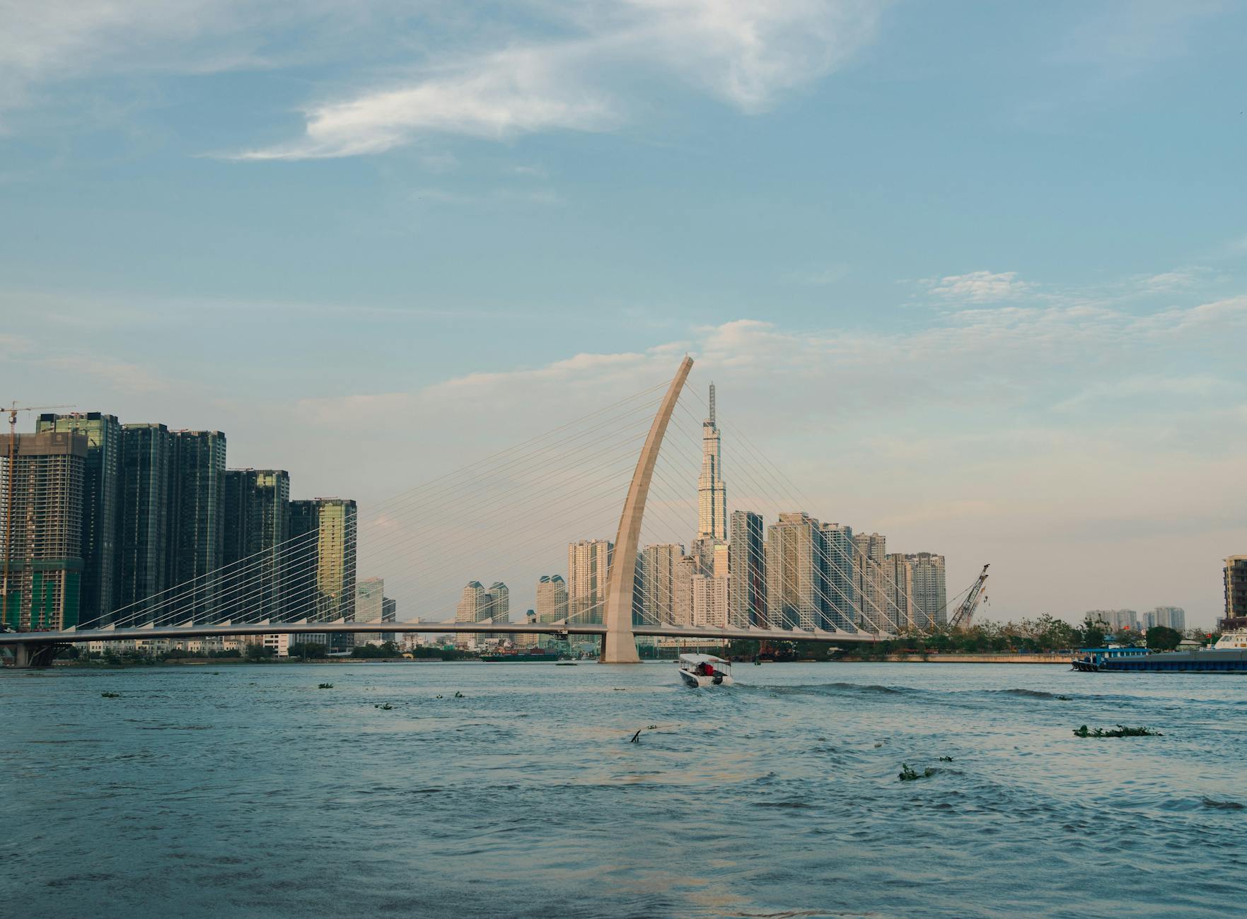 Scenic view of Saigon River with Thu Thiem Bridge and skyline in Ho Chi Minh City, Vietnam.