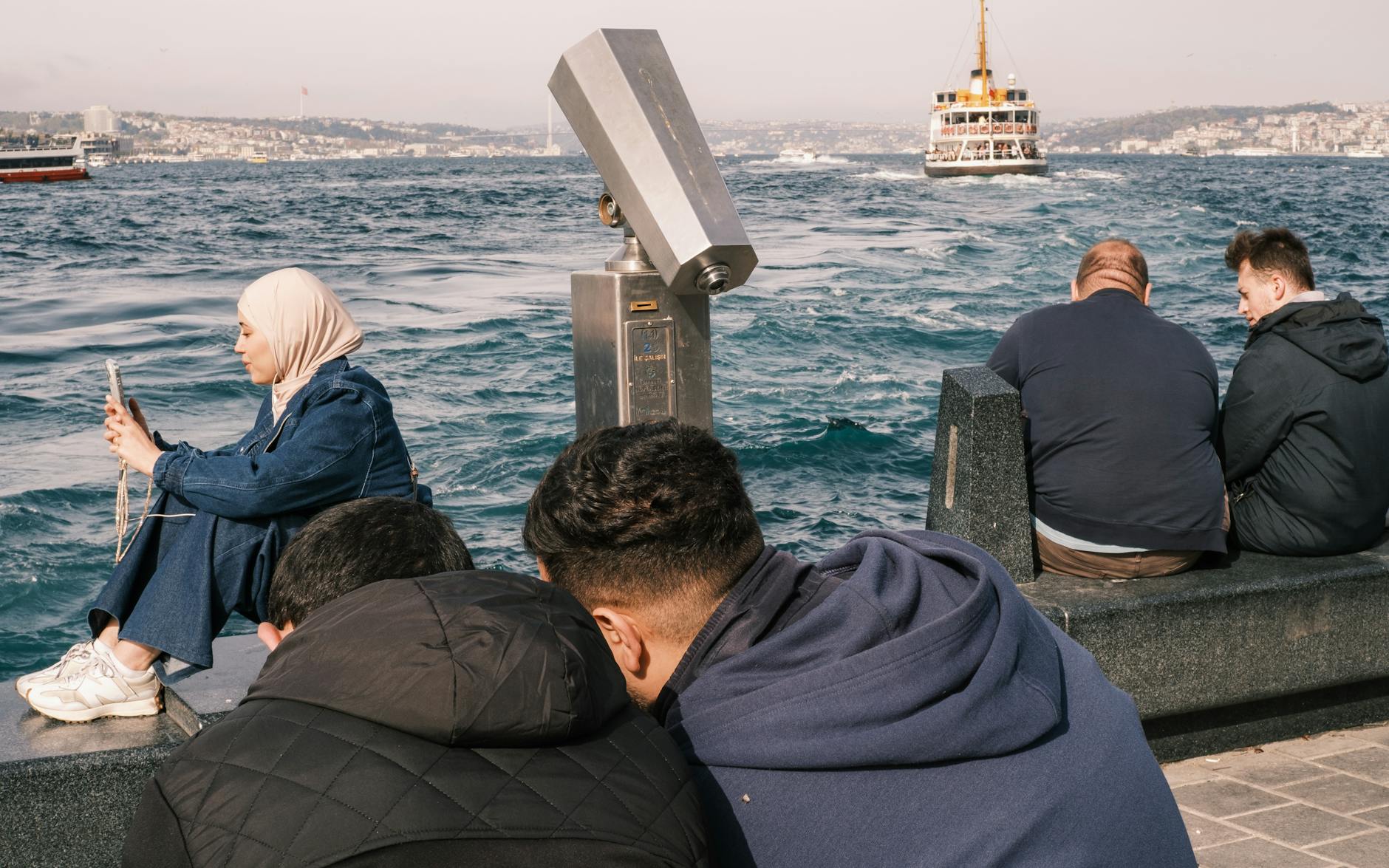 People enjoying a sunny day by the Bosphorus Strait, Istanbul, Turkey.