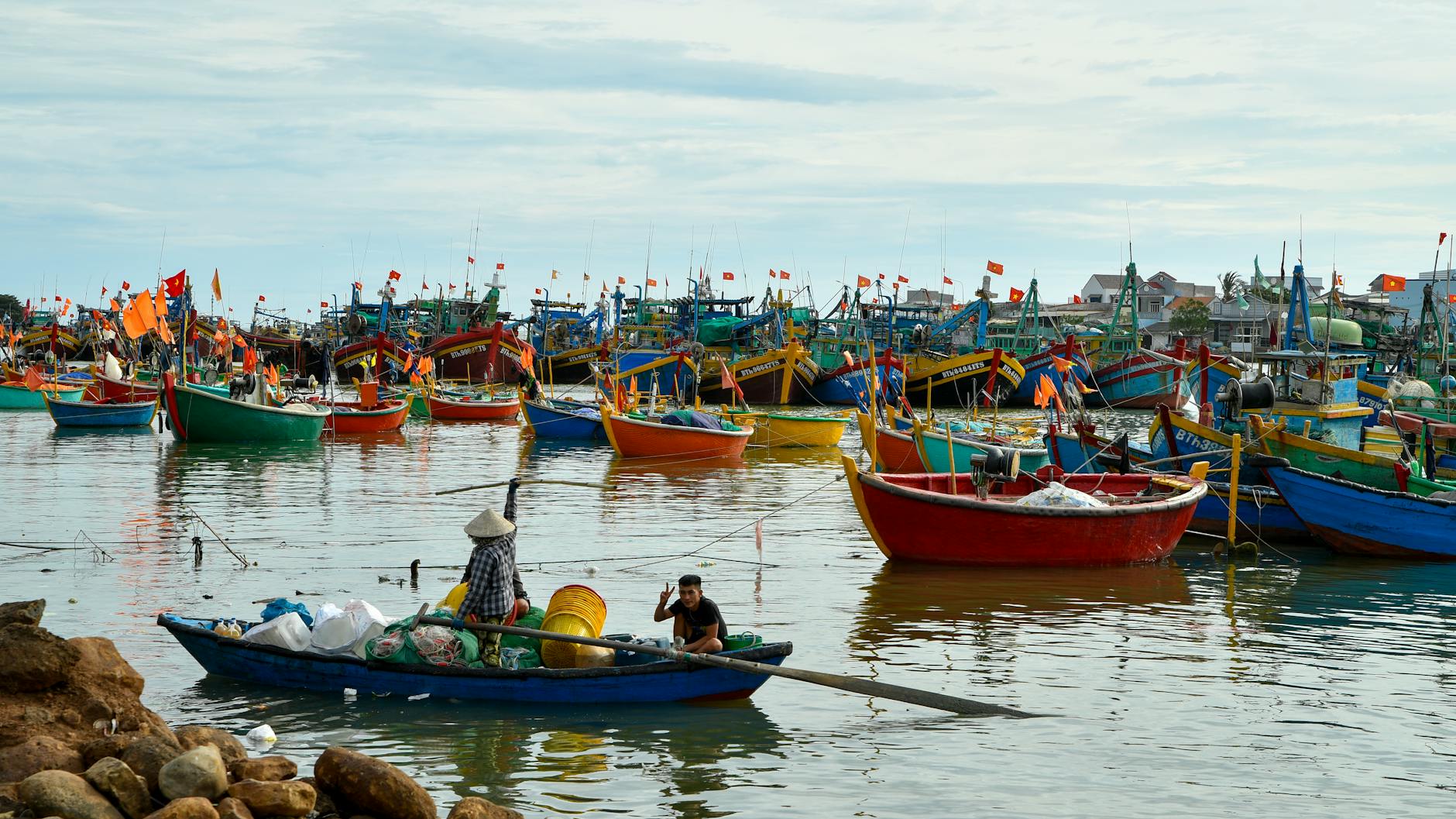Vibrant fishing boats in Phan Thiet harbor, capturing Vietnamese coastal life on a sunny day.