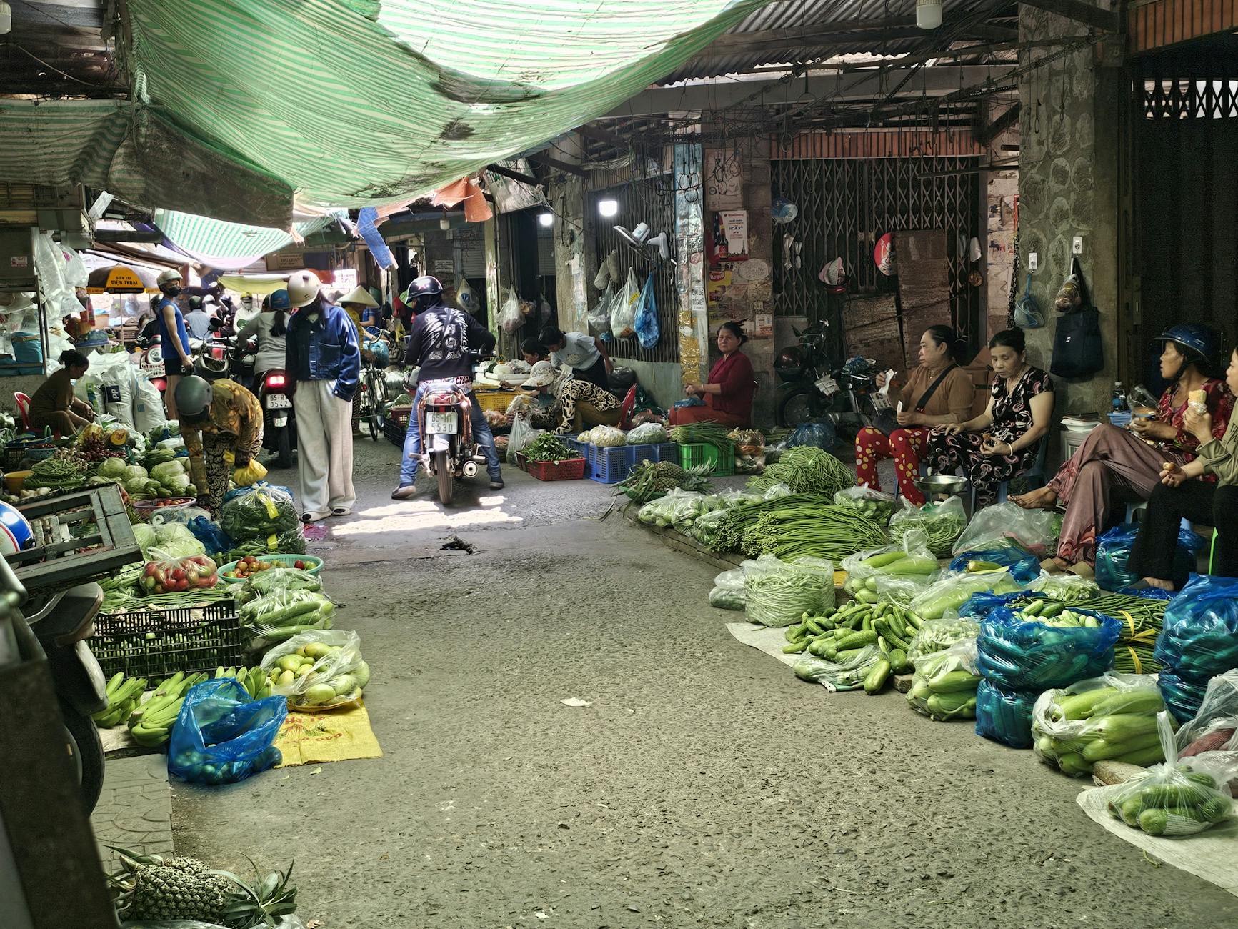 Vibrant indoor market scene in Vietnam with fresh vegetables and local vendors.