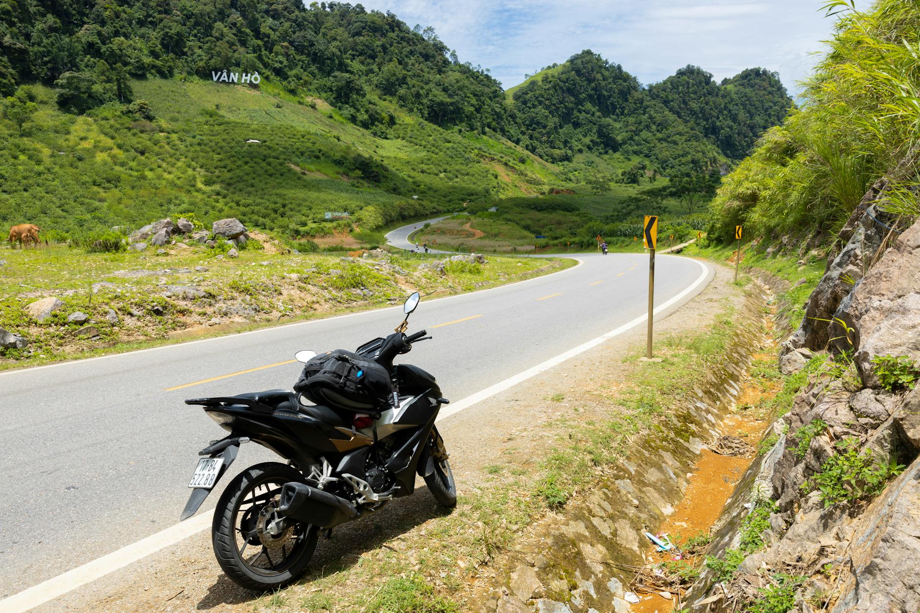 A peaceful motorcycle ride on the winding roads of Van Ho amidst lush mountains.