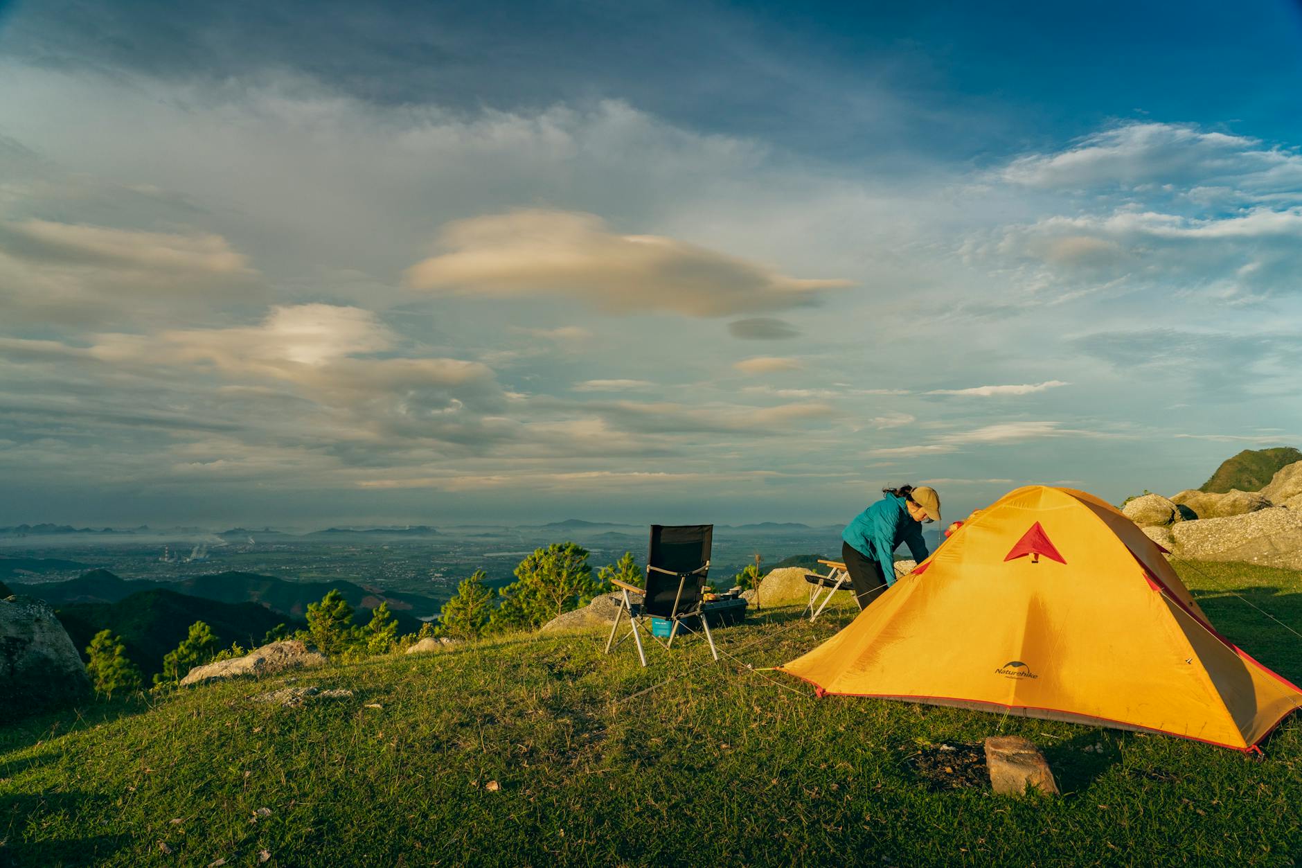 Peaceful camping moment in Quang Ninh, Vietnam, showcasing a vibrant morning scene with a tent and scenic mountain view.