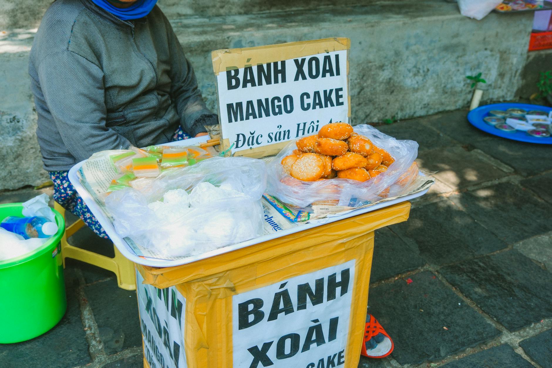 Mango cakes on a street market stall in Vietnam. Highlighting local cuisine and urban culture.