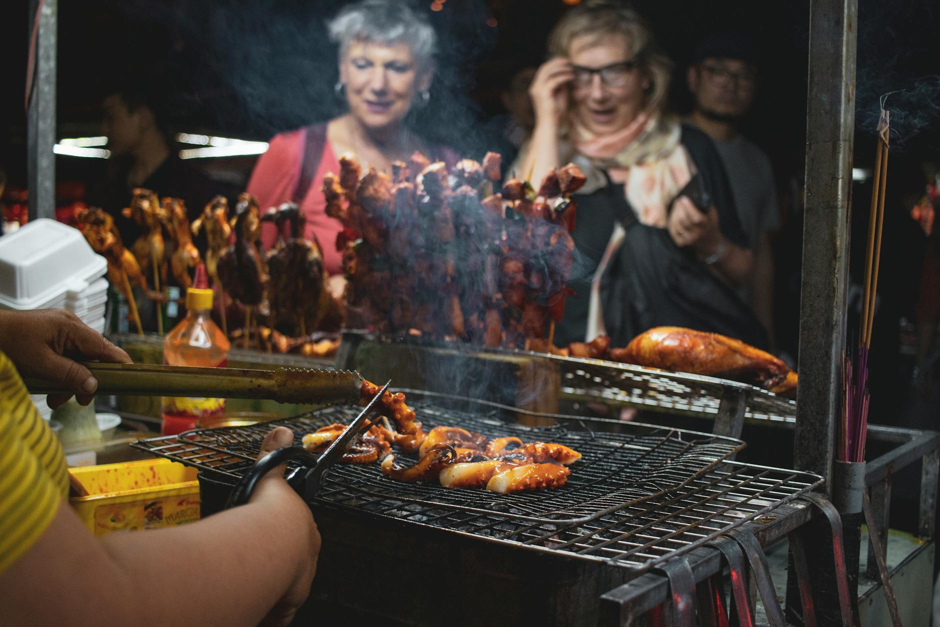 Vibrant street food barbecue scene at Hội An night market, featuring grilled seafood and skewers.