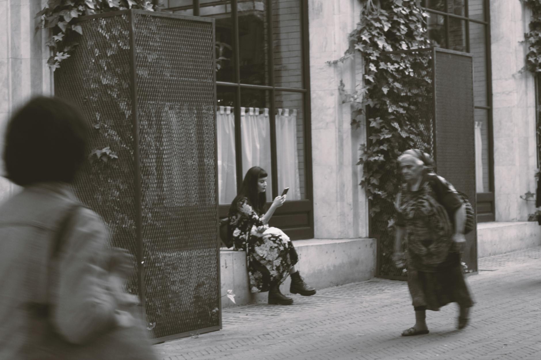 Black and white photo capturing people in motion on a city street.