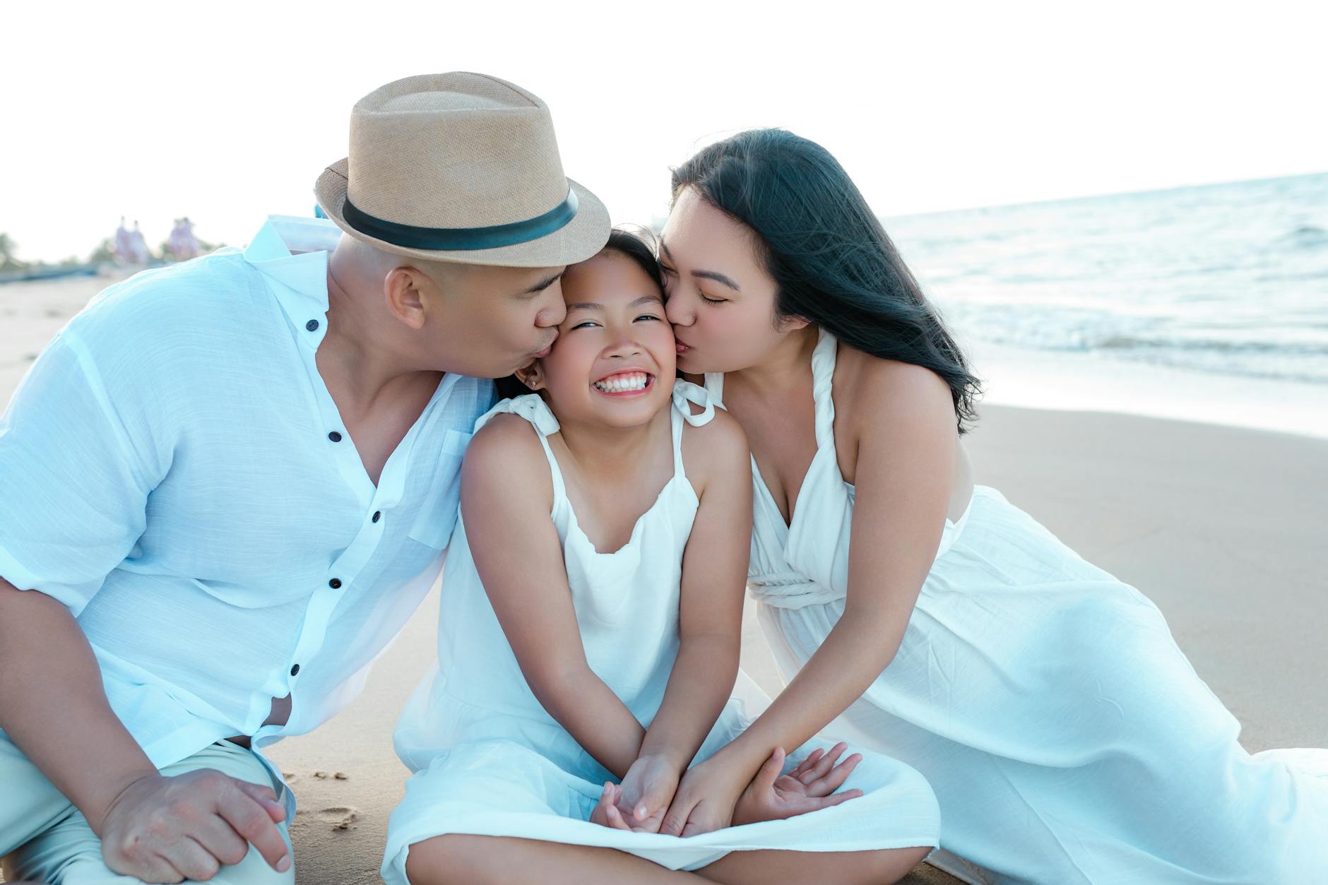Loving family embracing on the serene sands of Hội An beach in Vietnam, enjoying a joyful moment together.