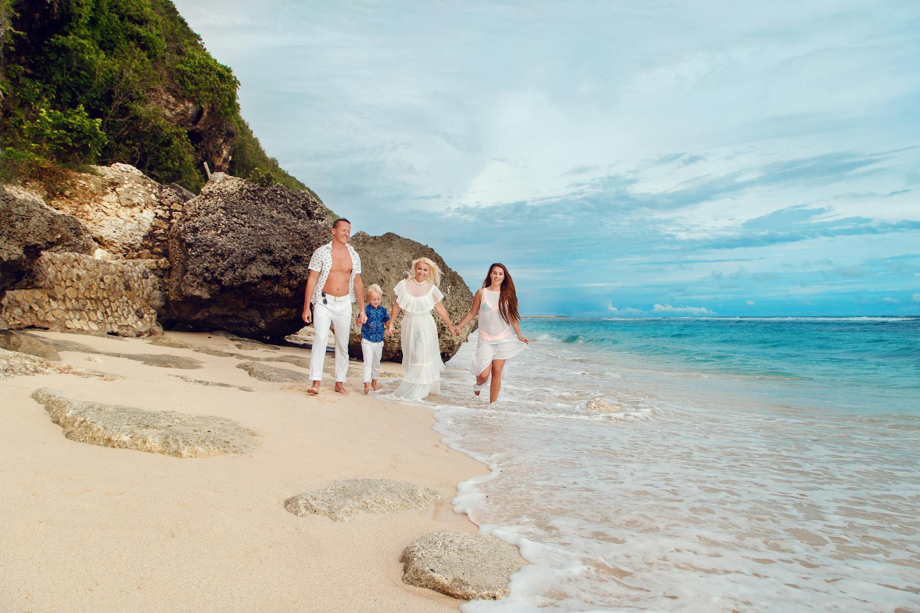 A happy family enjoying a walk on a beautiful Bali beach, capturing a moment of joy and togetherness.