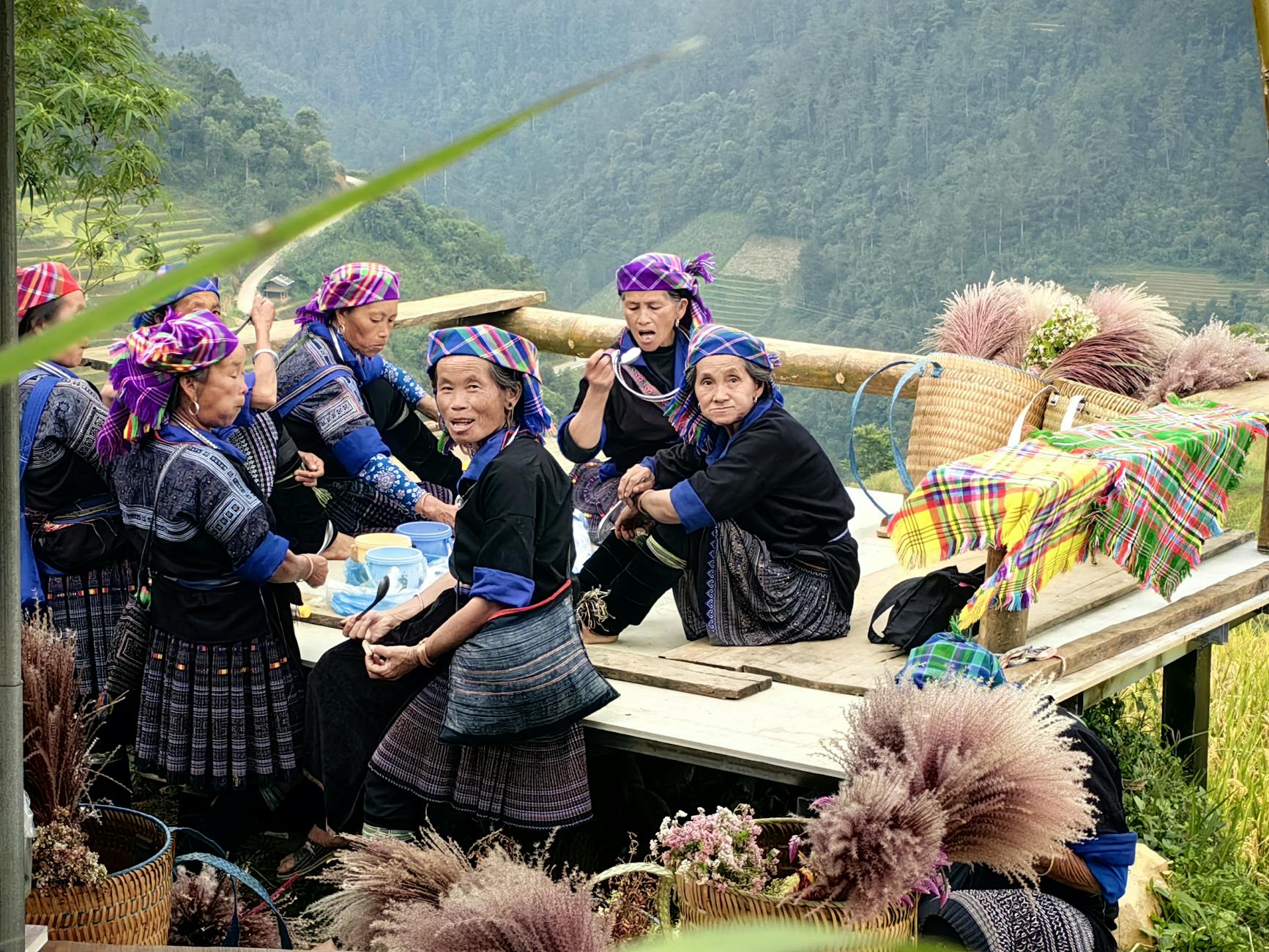 Hmong women enjoying a gathering amidst the scenic rice terraces of Mu Cang Chai, Vietnam.