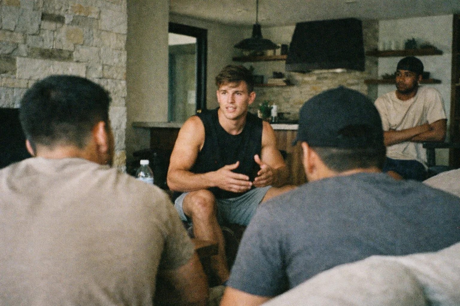 A Den leader instructing two men in conversation