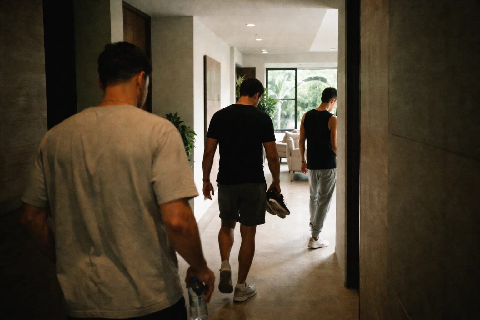 Three men walking through the Den hallway into the living room