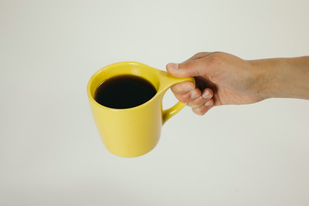 Nahaufnahme einer Hand, die eine Kaffeekapsel in eine Kapselmaschine einführt, geringe Schärfentiefe | Foto: Battlecreek Coffee Roasters