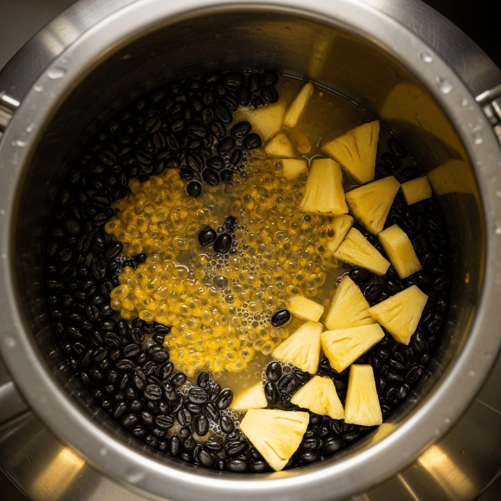 Edelstahl-Fermentationstank gefüllt mit rohen Kaffeebohnen, Maracuja und Ananas für die Co-Fermentation.