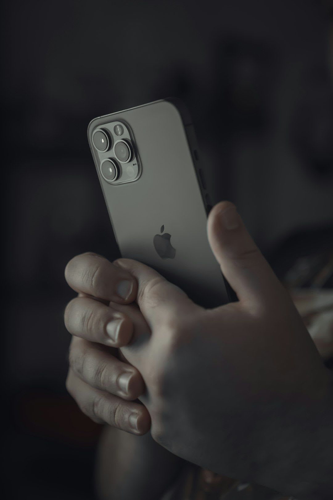 Person nutzt nachts ein iPhone, auf dem eine Warnung für niedrigen Akku erscheint – eine Folge von stromfressenden Apps. | Foto: Onur Binay