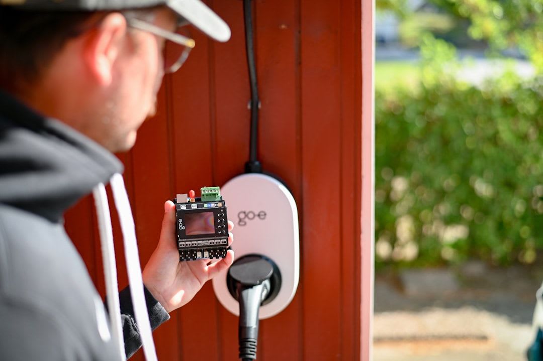 Hand bedient ein smartes Thermostat, um Heizkosten zu senken und den Stromverbrauch im 2-Personen-Haushalt zu optimieren. | Foto: go-e