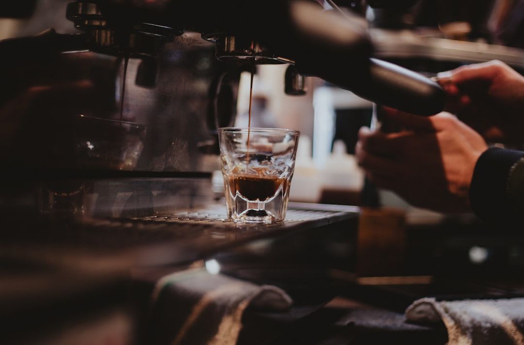 Eine Hand stellt den Kaffee Mahlgrad am Stellrad im Bohnenbehälter eines Vollautomaten für den optimalen Espresso ein. | Foto: Jason Betz