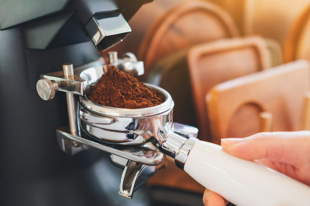 Nahaufnahme einer elektrischen Kaffeemühle in Aktion, ein ideales Weihnachtsgeschenk 2026 für ambitionierte Kaffeeliebhaber. | Foto: Nguyen Tong Hai Van