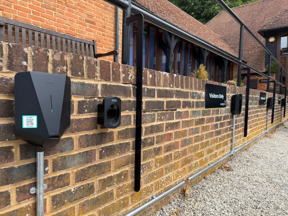 Wall mounted Easee chargers beside a Visitors Only bay sign at the Purdicom offices in Wantage.