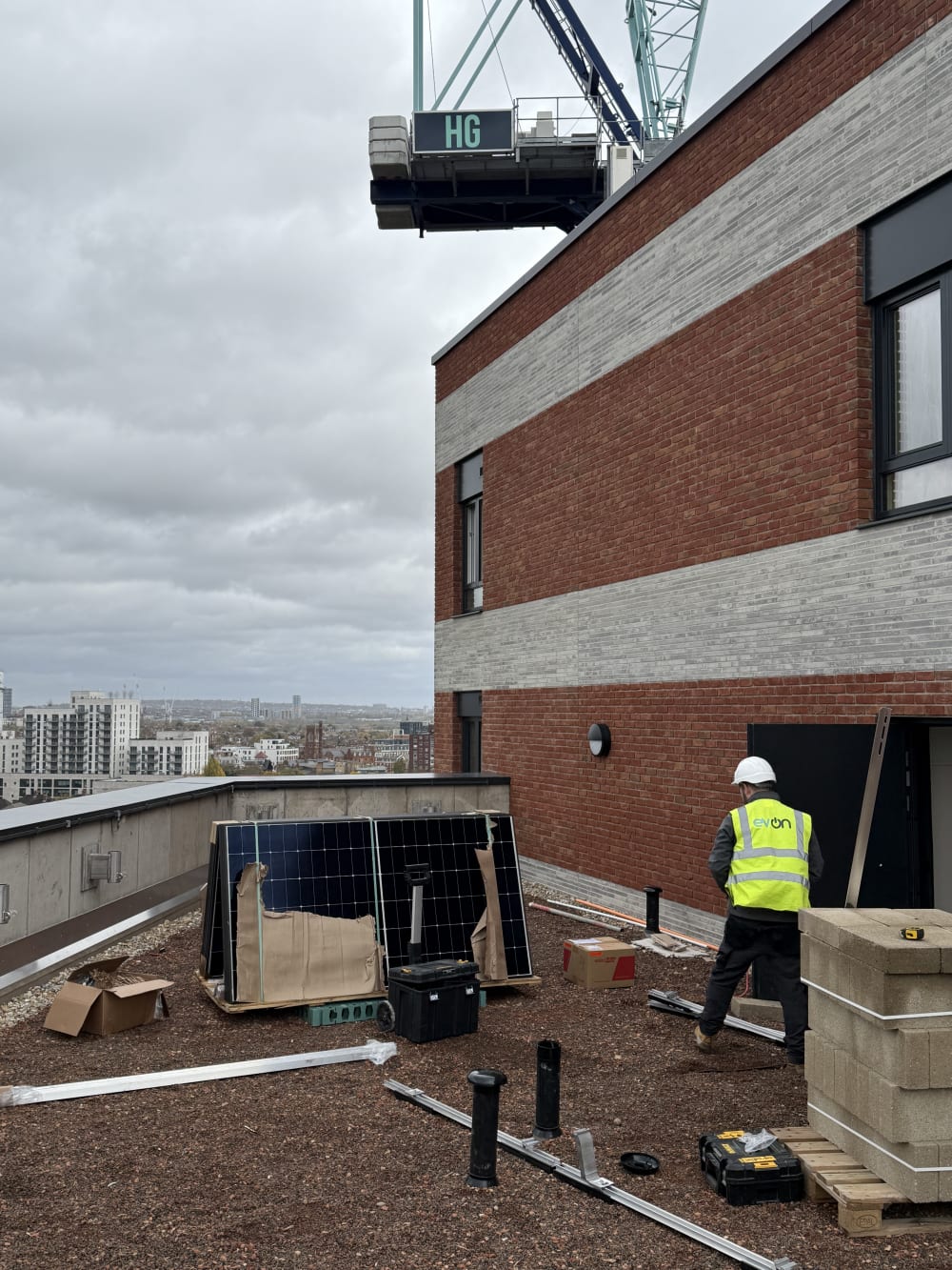 First Longi solar panels being positioned onto K2 S-Dome mounting on the 13th floor roof at Brooke House, Gunnersbury Lane, Acton.