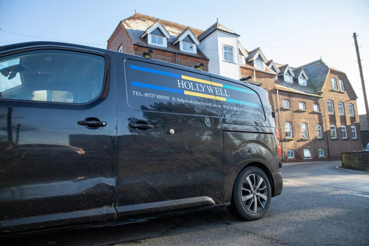 A branded Hollywell Building Services van parked outside the company office building in St Albans.