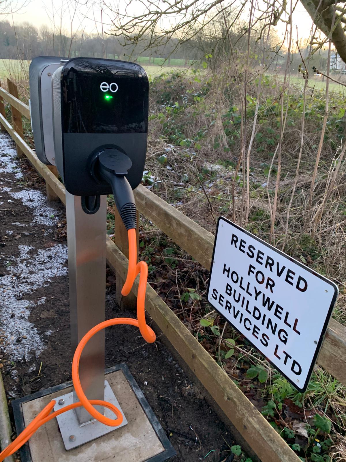 Close-up of an EO Genius 2 charger with green LED and orange Type 2 cable connected at Hollywell in St Albans.