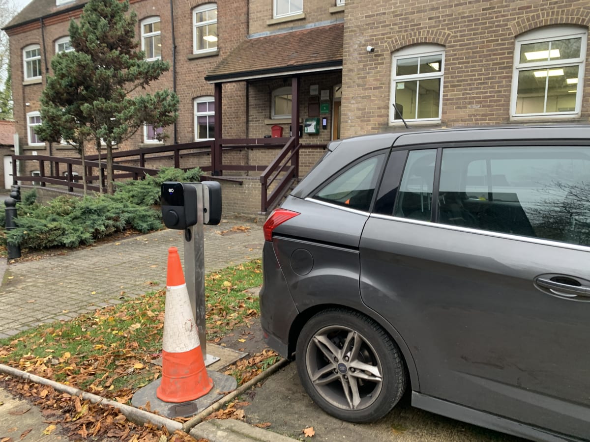 An EO Genius 2 22kW charger installed on a pedestal near the office entrance at Hollywell's St Albans premises.