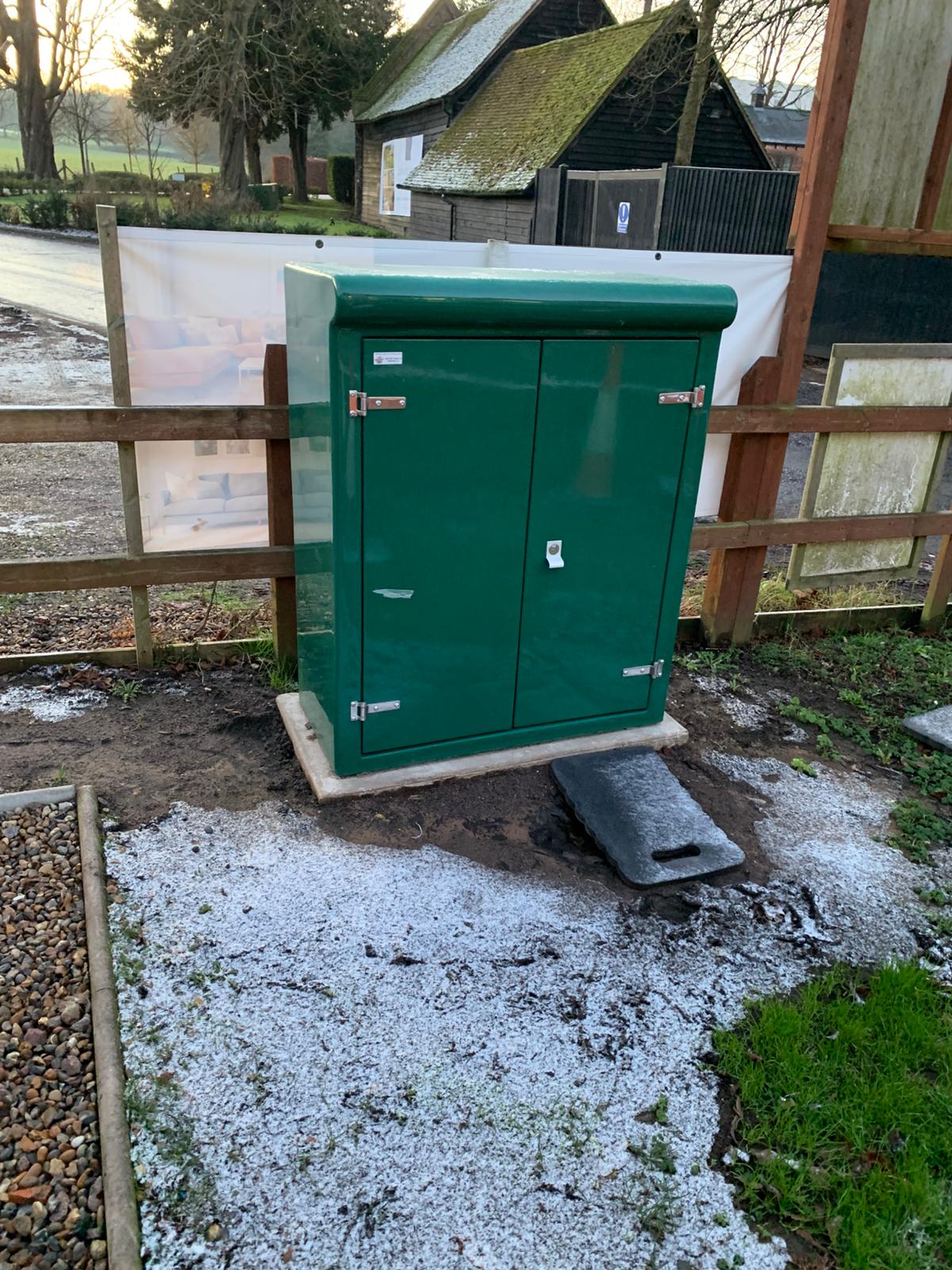 A green GRP electrical enclosure installed on a concrete base to power fleet EV chargers at Hollywell in St Albans.