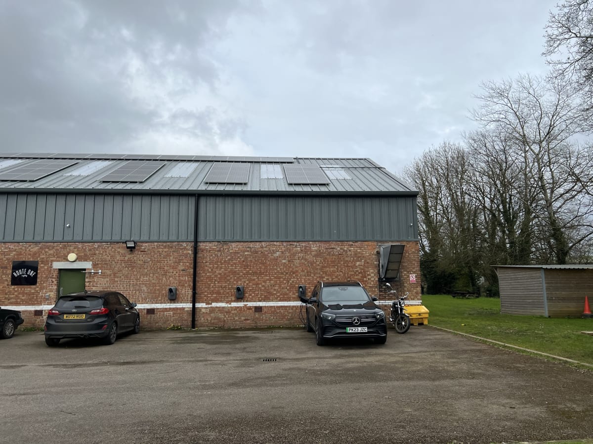 Route One warehouse with SolarEdge solar panels on the roof and EV chargers on the wall at Acton Turville