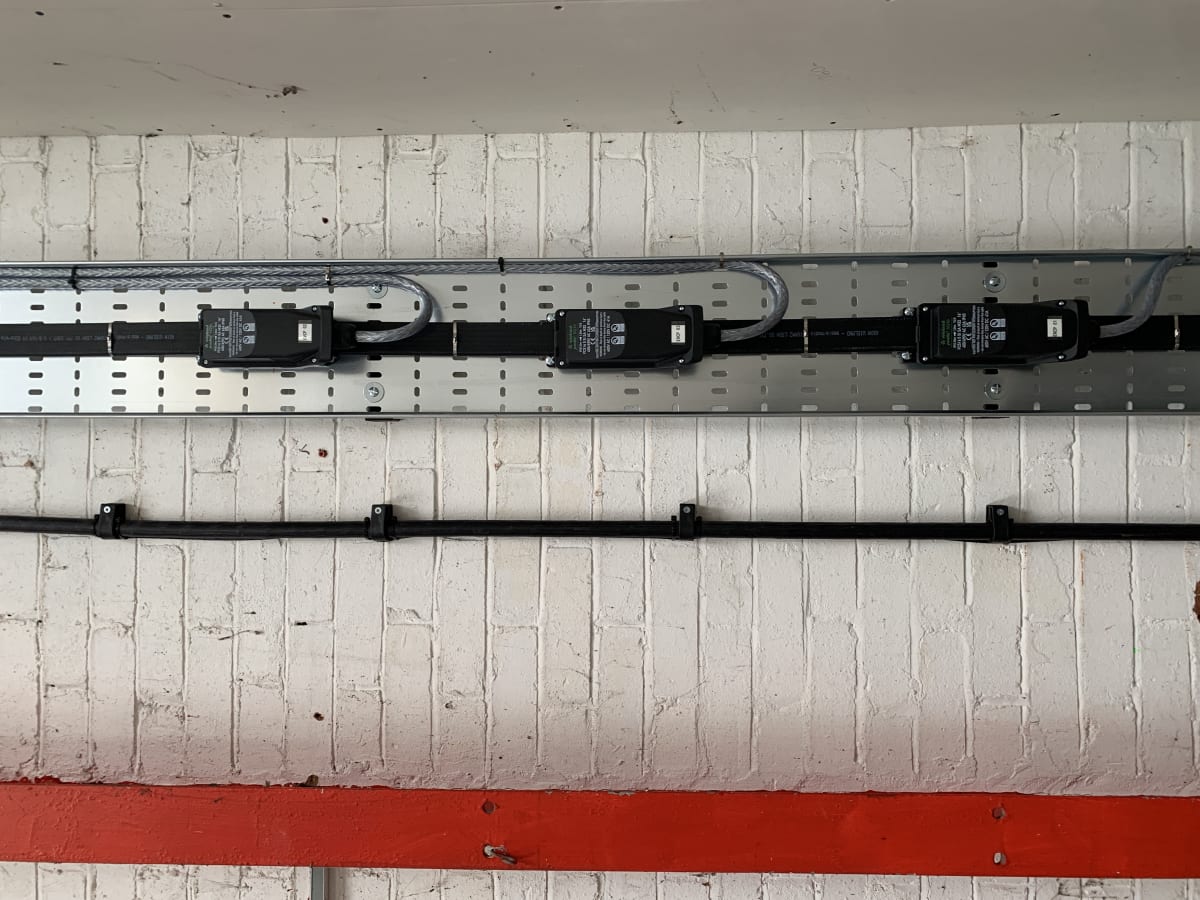 Wieland Podis flat cable system with four tap-off modules installed at high level inside Route One warehouse, Acton Turville