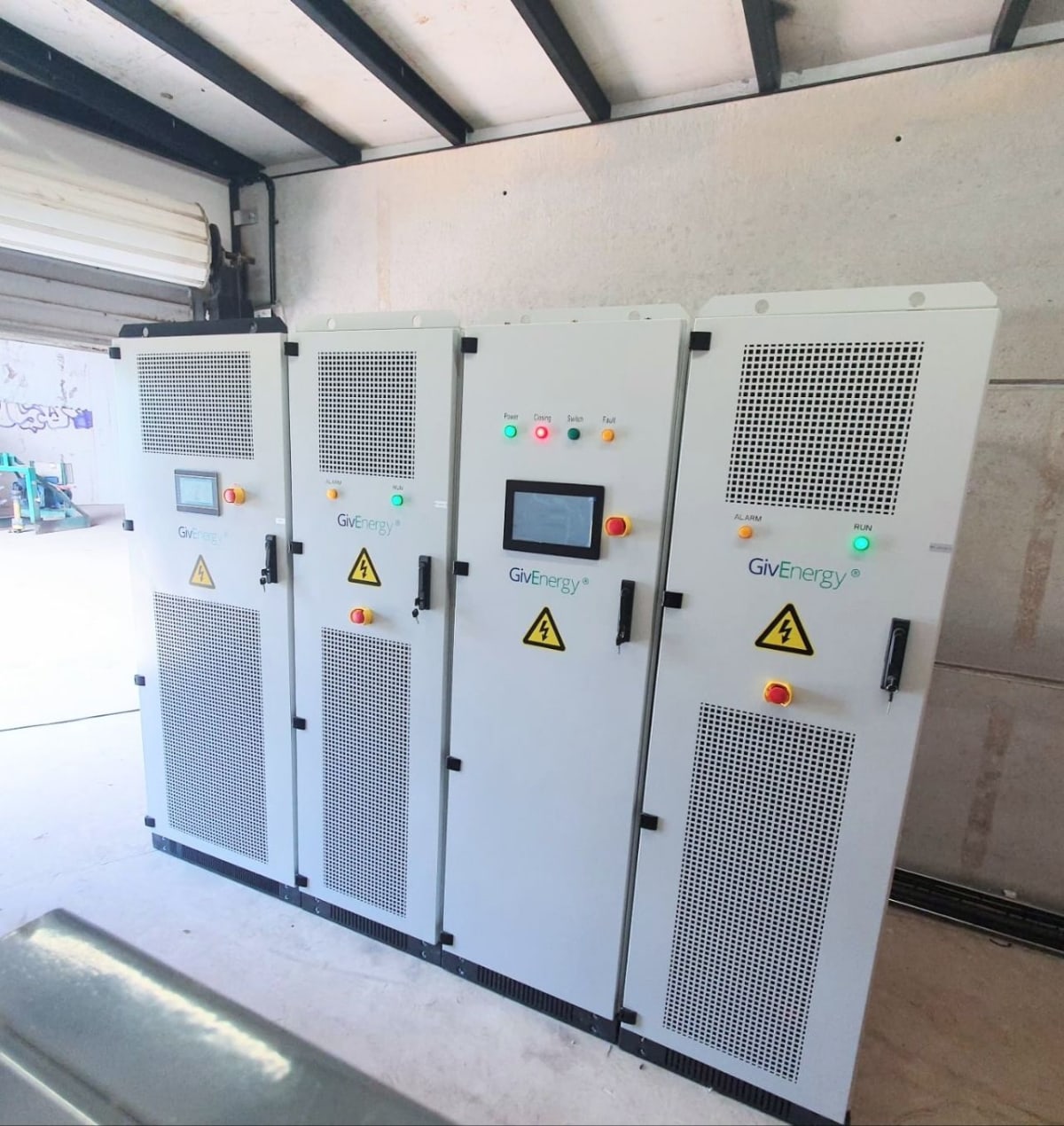 A row of GivEnergy commercial battery storage cabinets installed by evon