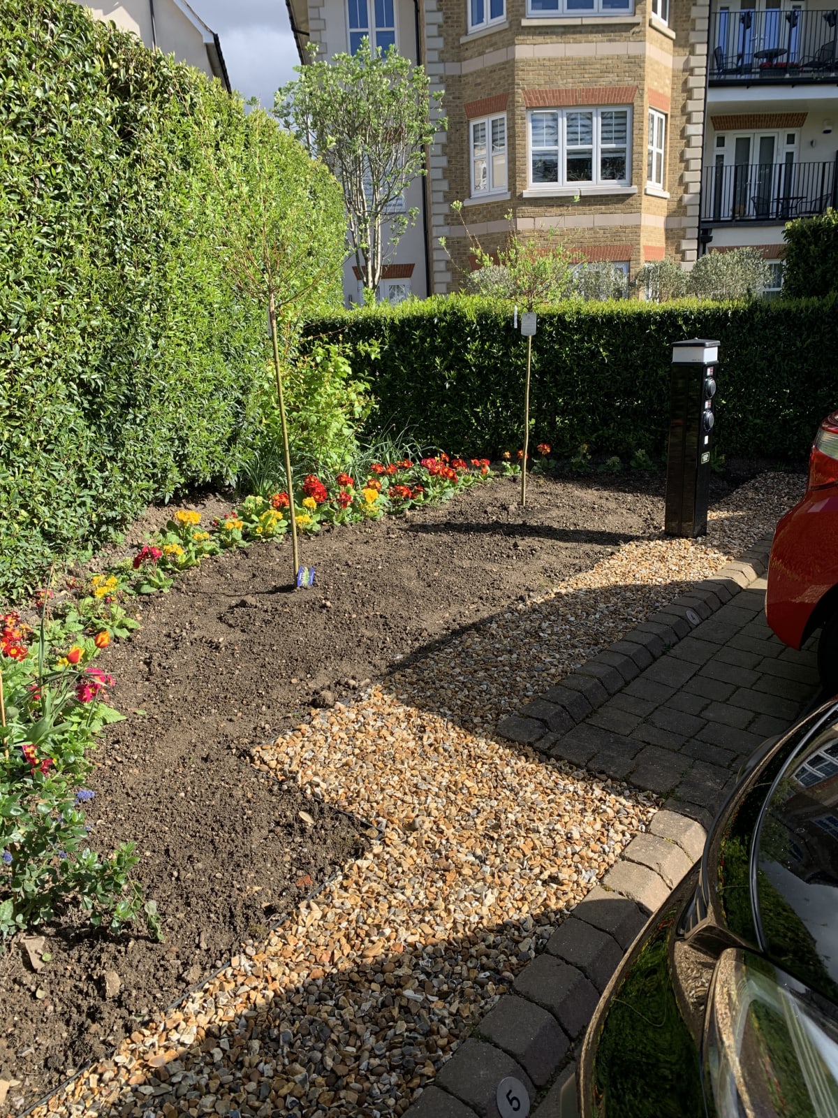 Completed landscaping reinstatement with shingle and planting after EV charger installation at Ashby Lodge, Hendon