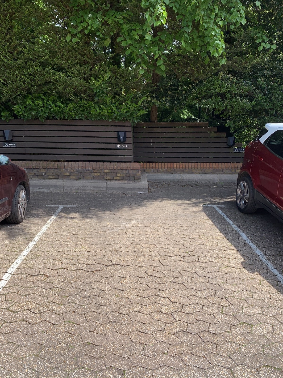 The reinstated Z-block paving car park at Hill Court, Highgate with EV chargers visible on the perimeter fence
