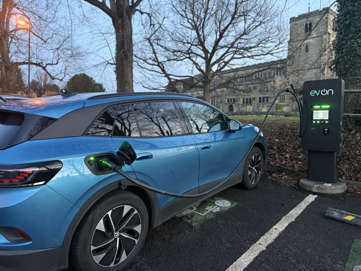 Electric vehicle charging on an EV-ON public EV charger with Cranbrook church in the background.