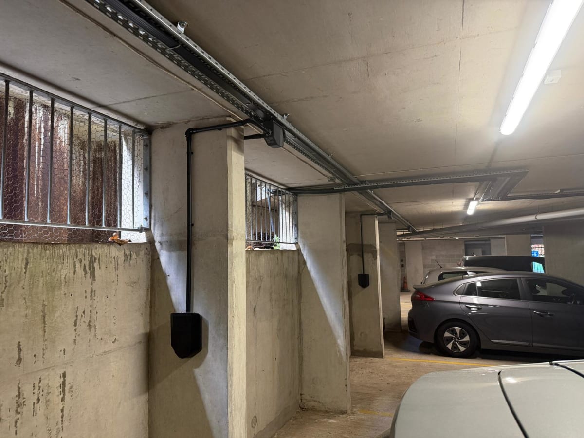 Wide view of the Wieland flat cable busbar run with Easee EV chargers mounted on concrete pillars at Portland Court underground car park, Hendon, London.