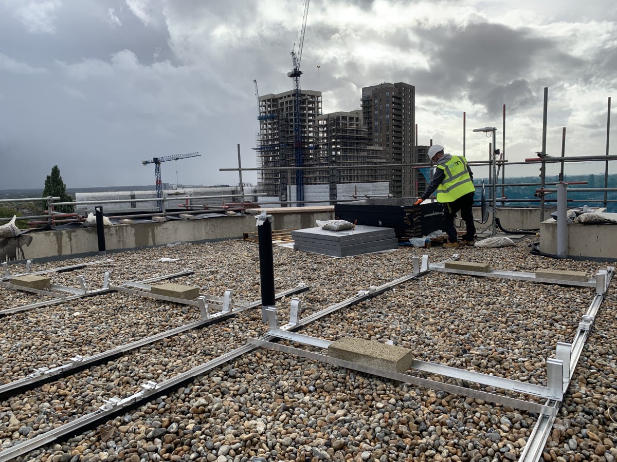 K2 D-Dome Xpress solar mounting rails laid across the flat roof at The Mirador, Acton, with London cranes visible behind.