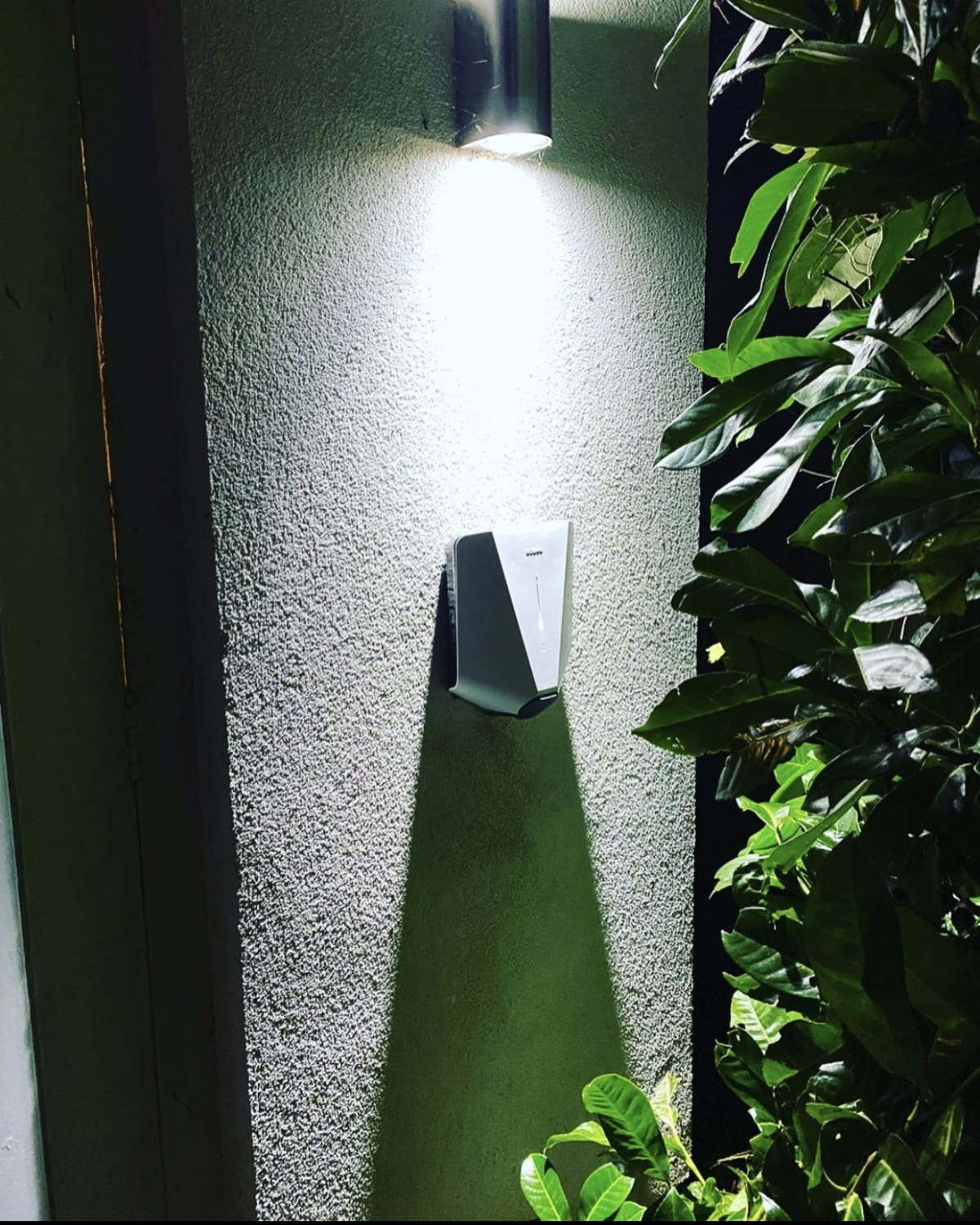 An Easee home charger installed on a house wall in the evening