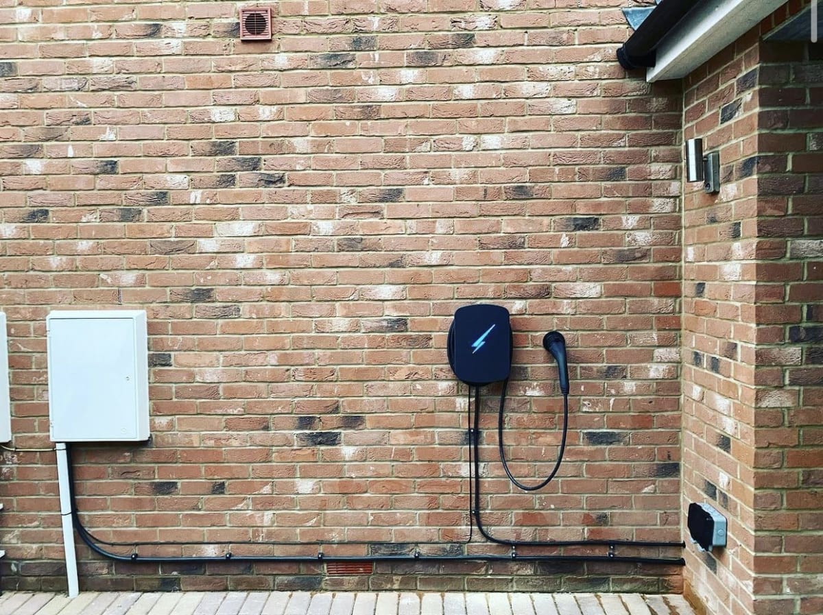 A Hypervolt home EV charger newly installed on a brick wall