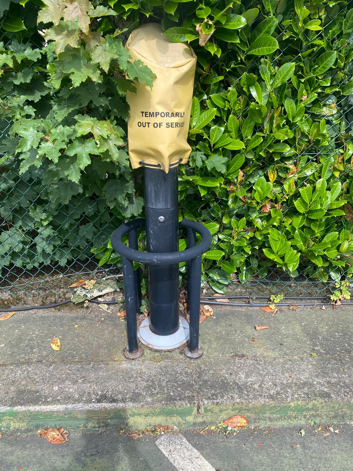An EV chargepoint bollard covered with a yellow temporarily out of service bag after a fault