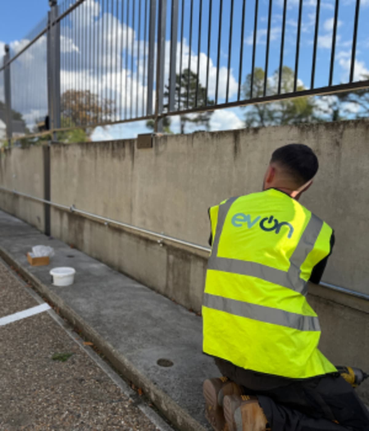 EV-ON installer in branded hi-vis vest working on the EV charging installation at Touchlight, Hampton.