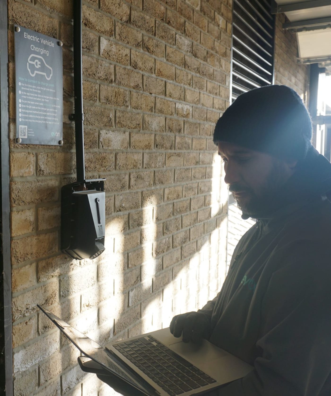 evon engineer diagnosing an EV charger fault on site with a laptop