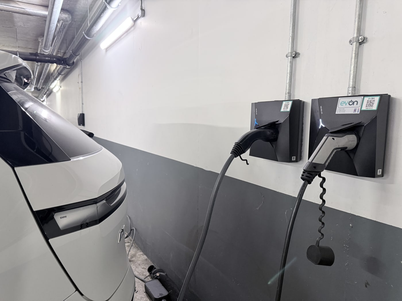 Two Nexblue chargers beside a white electric car in the underground car park at The Avenue, Kilburn