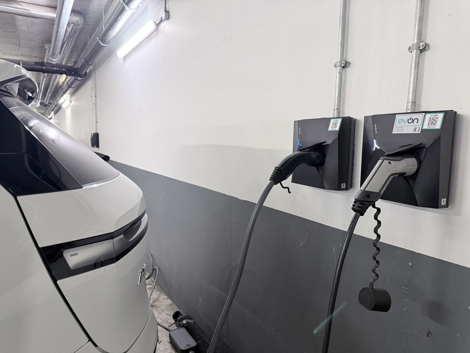 Two Nexblue Point 2 7kW chargers beside a white electric car in the underground car park at The Avenue, Kilburn.