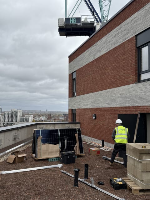 First Longi solar panels being positioned onto K2 S-Dome mounting on the 13th floor roof at Brooke House, Gunnersbury Lane, Acton.